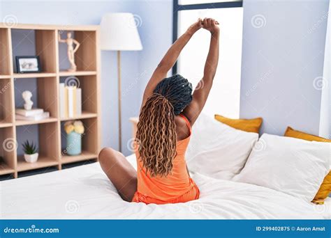 African American Woman Waking Up Stretching Arms At Bedroom Stock Image