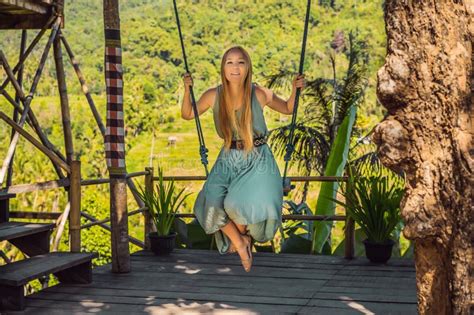 Young Woman Swinging In The Jungle Rainforest Of Bali Island Indonesia