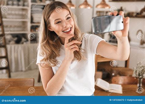 Portrait Of Satisfied Blond Woman Taking Selfie Photo On Smartphone