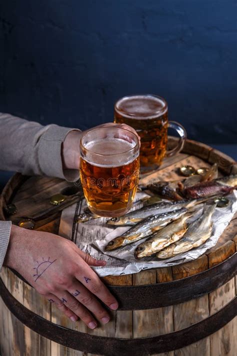 Cerveza De La Bebida Del Hombre Con Los Pescados Secados Foto De