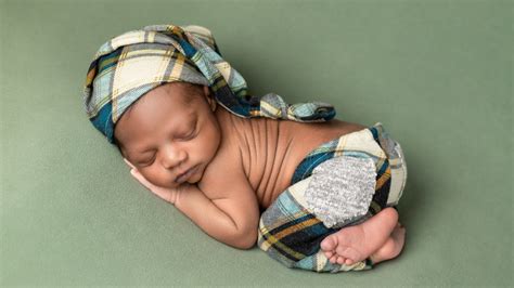 Newborn baby boy sleeping on his stomach on green fabric with cute ...