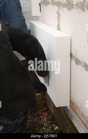 Builder Installing Rigid Styrofoam Insulation Board For Energy Saving