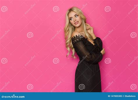 De Gelukkige Blonde Vrouw In Zwarte Kantkleding Kijkt Weg Over The Shoulder Stock Afbeelding
