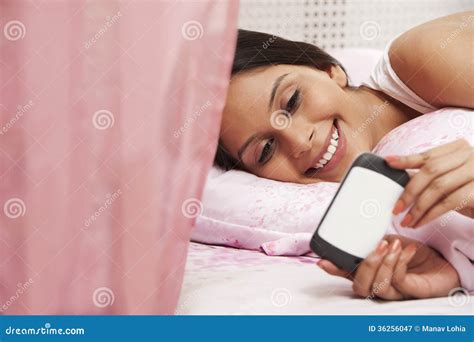 Woman Text Messaging On A Mobile Phone On The Bed Stock Image Image