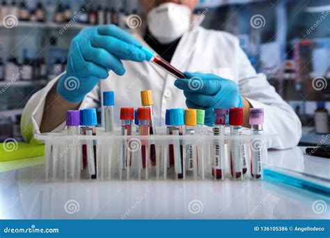 Lab Technician Holding Blood Tube Of The Rack In The Hematology