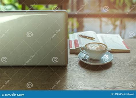 Laptop And Cup Of Coffee And Cell Phone With Books And Pen On Wooden