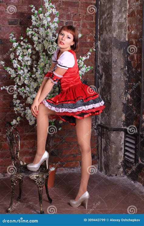 Long Legged Redhead Girl In Shiny Pantyhose And Red Minidress Posing At The Sakura Stock Image