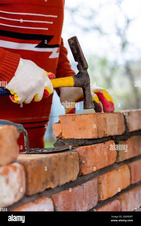 Un Hombre Construye Una Pared De Ladrillo Pone Un Ladrillo En Un