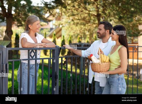 Friendly Relationship With Neighbours Young Couple With Wicker Basket