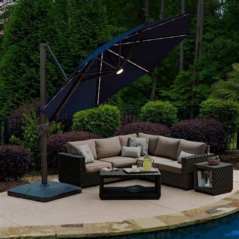 an outdoor patio furniture set with umbrella and table next to a pool in the backyard