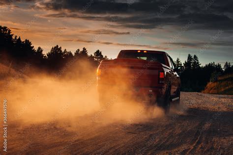 Pickup Truck In Motion On A Country Road With Clouds Of Dust An Suv Is