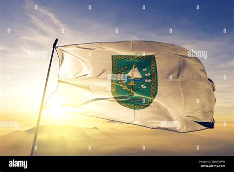 Riau province of Indonesia flag waving on the top sunrise mist fog Stock Photo - Alamy