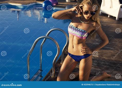 Sexy Vrouw Met Lang Haar In Bikini Het Ontspannen Naast Een Zwembad Stock Afbeelding Image Of