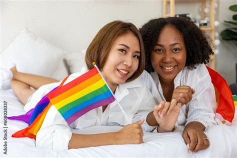 Couple Of Same Sex Marriage From Difference Races With LGBTQ Rainbow Flag For Pride Month While