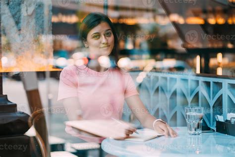 Beautiful Brunette Sitting Behind A Window In A Cafe Bar 11455751 Stock Photo At Vecteezy