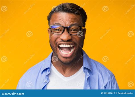 Millennial Black Man Laughing Looking At Camera Over Yellow Background