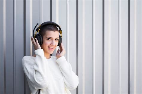 Femme Aux Cheveux Courts écoutant De La Musique Au Casque Et Regardant