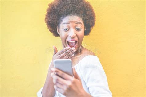 Young Black Woman Standing Isolated Over Yellow Background Using Smart Mobile Phone African