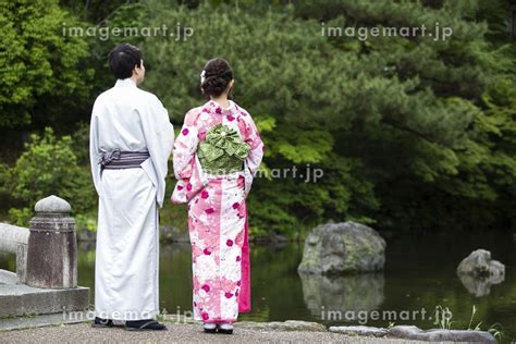 池のほとりで立つカップルの写真素材 [34335075] イメージマート