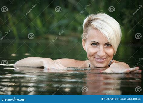 Close Up Of A Woman Blonde Middle Aged Nude Swims In The River Selective Focus Stock Photo