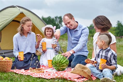 Feliz Familia Comiendo Sand A En Picnic En Pradera Cerca De La Tienda