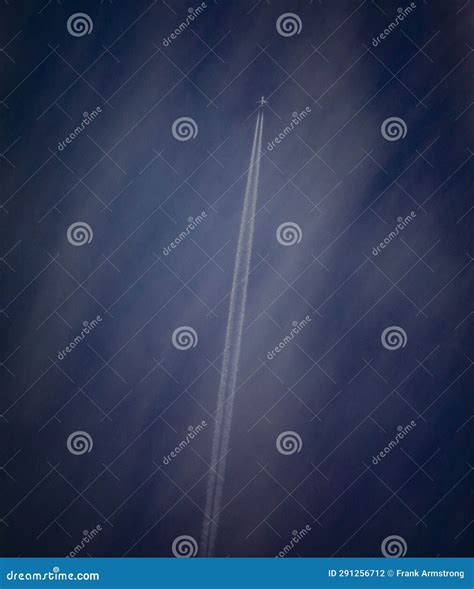 Airplane At High Altitude Flying In Cirrus Clouds With A Contrail