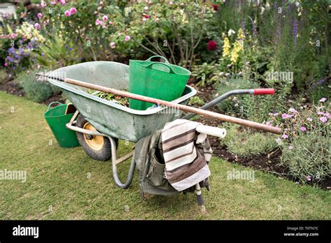 National Trust Gardeners Wheelbarrow With Tools And Trugs On The Lawn