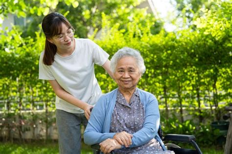 El Cuidador Ayuda Y Cuida A Una Anciana Asi Tica Que Usa Un Andador Con