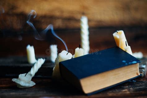 Three Magic Books In Candlelight On The Wooden Table In The Darkness