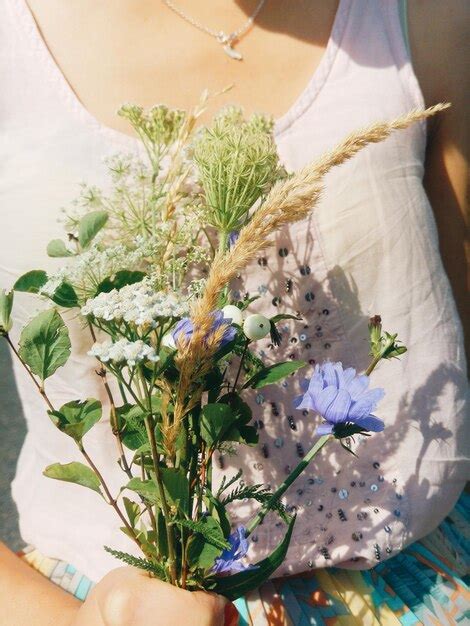 Premium Photo Midsection Of Woman Holding Flowers