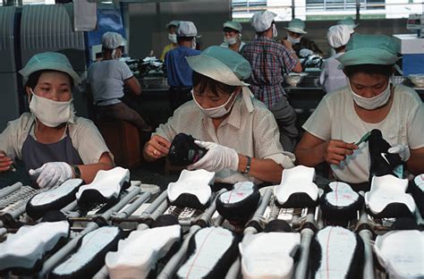 Workers in a Nike factory near Ho Chi Minh City use glue to... Pictures ...