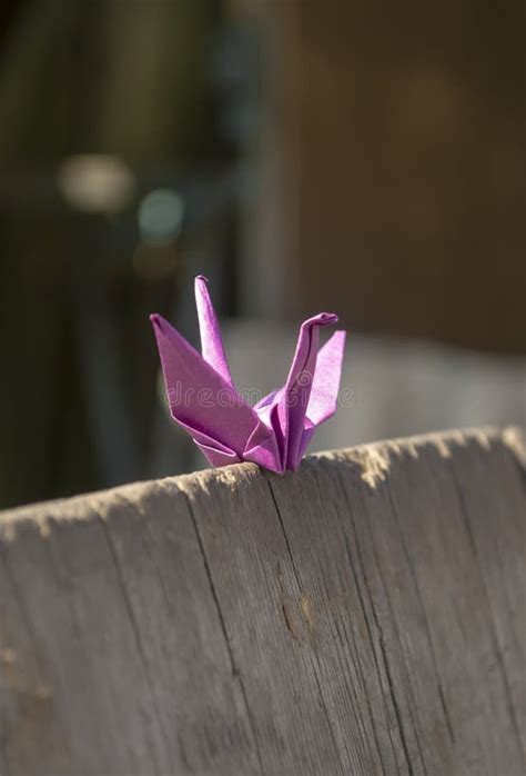 A Purple Paper Crane Stands On A Wooden Board Origami Is A Paper Crane