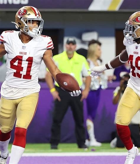 Two Football Players Are Running On The Field