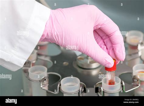 Doctor Puts Test Tube Of Blood To Centrifuge Machine In Medical Clinic