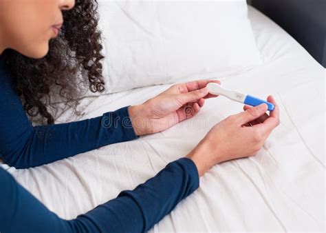 Close Up Of Hands Holding Positive Pregnancy Test With Two Pink Lines