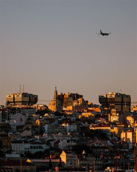 Premium Photo Airplane Flying Over Buildings In City Against Clear Sky