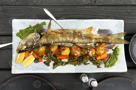 Whole baked fish with vegetables 9399927 Stock Photo at Vecteezy