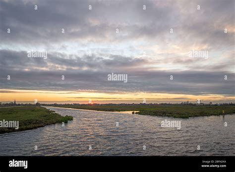 Clouds At Sunset Over The Flat Wide Open Dutch Polder Landscape Green