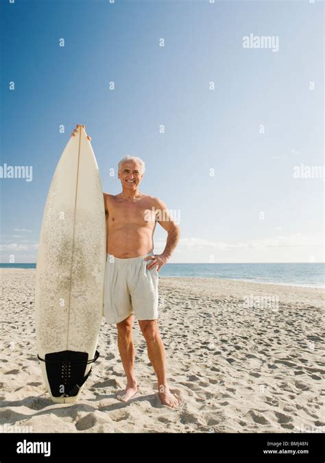 Man Holding Surfboard On Beach Stock Photo Alamy