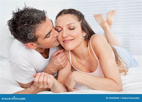 Homem Que Beija A Mulher Na Cama Foto De Stock Imagem De Amar