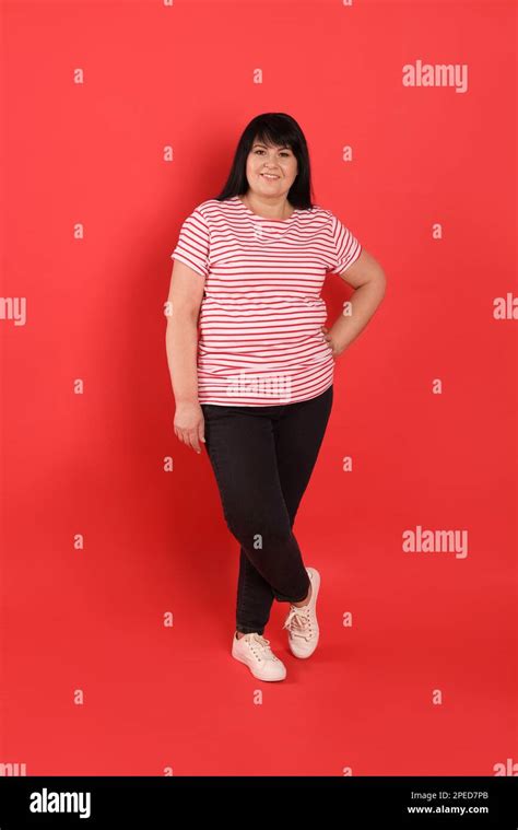 Beautiful Overweight Mature Woman With Charming Smile On Red Background Stock Photo Alamy