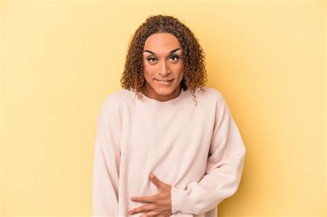 Joven Transexual Latina Aislada De Fondo Amarillo Toca La Barriga Sonr E Suavemente Come Y El