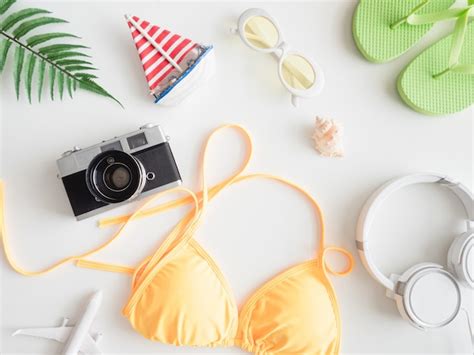 Premium Photo Top View Travel Concept With Bikini Luggage And Outfit Of Traveler On White