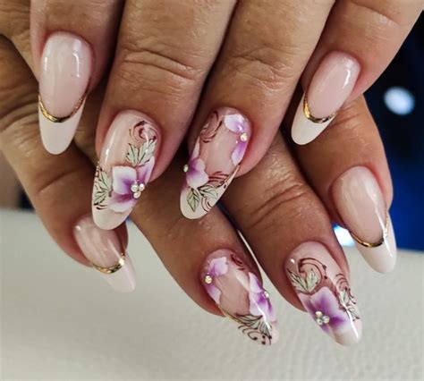 A Woman S Hand With Pink And White Flowers On It Holding Onto Her Nails