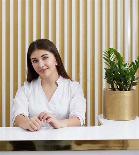 Female Receptionist At Reception Desk In A Modern Office Lobby Stock