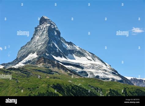 Summit of Matterhorn mountain with alpine meadows and pine forests near