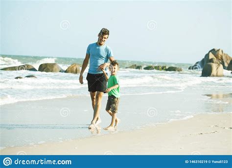 Familia Feliz En La Playa Que Juega Padre Con La Costa De Mar Del Hijo