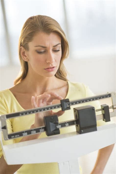 Femme Ajustant L échelle De Poids Au Club De Santé Photo stock Image