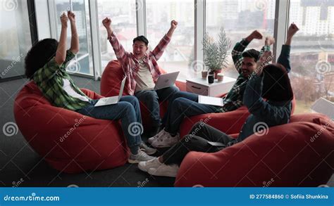 Employees Putting Hands In Air While Working In Open Office Stock