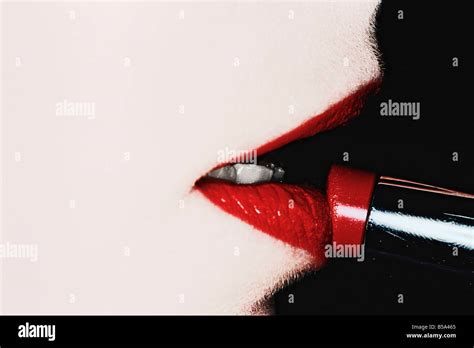 Woman Putting On Lipstick Stock Photo - Alamy